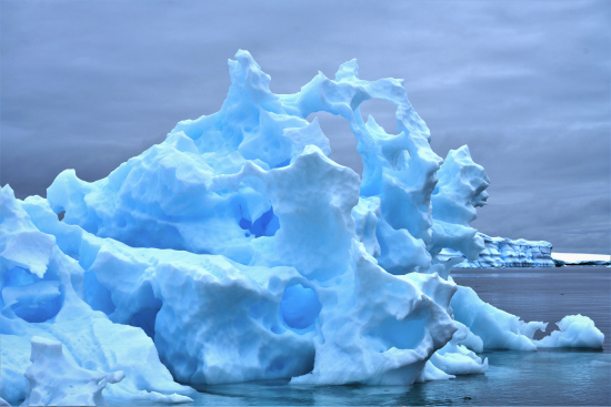 Melting iceberg against a cloudy sky backdrop